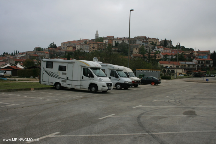 Der Parkplatz, hinter dem PKW die Toiletten im Hintergrund die Altstadt