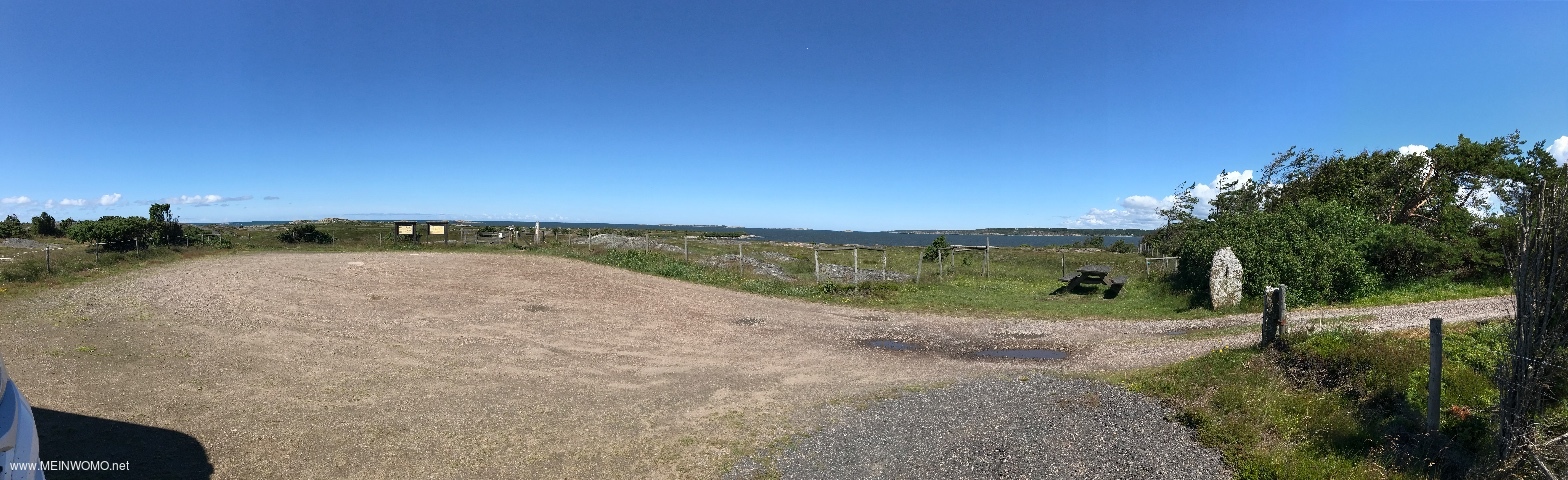 Schotterparkplatz mit Blick auf das Meer und einer Picknickbank