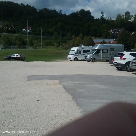 De parkeerplaats bevindt zich tussen de auto en de parkeerplaats van de bus. 