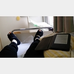 Im Krankenhaus Buchloe auf dem Bett lesend und die modischen Schuhe betrachtend.