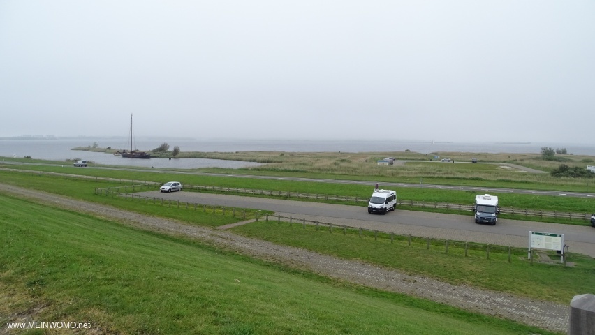  View from the dike onto the day car park (in the background)..  There is another day parking space  ...