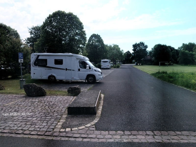 Place de parking, btiment sanitaire au fond  droite.