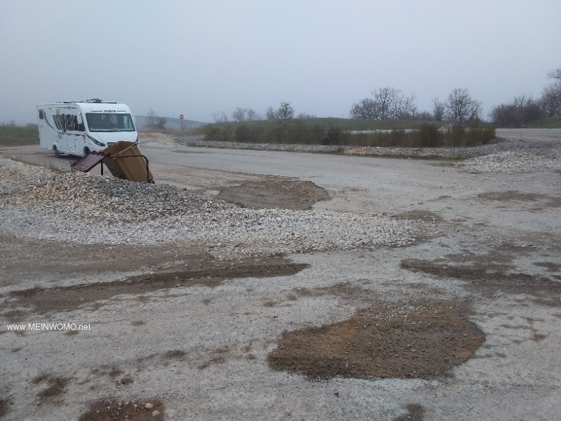 Large gravel area with lots of potholes