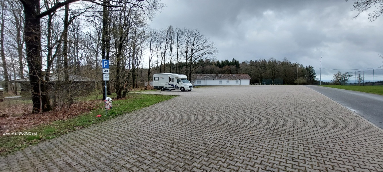 Parkeringsplats vid idrottsplatsen med husbils registreringsskylt 