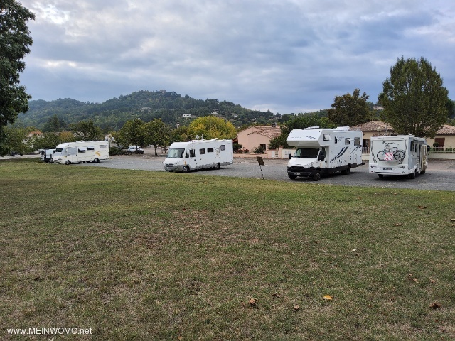 Wide, marked parking bays reserved for motorhomes on a busy road. 