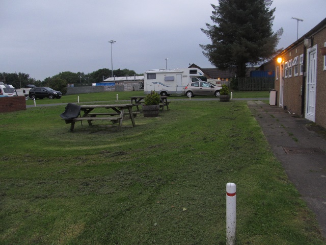 Zeigt rechts Sanitranlage und im Hintergrund Sportplatz