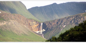 Der Fosselvfossen  das Wanderziel mit dem Teleobjektiv heran gezoomt von einem 5 Kilometer entfernten Standort auf der gegenber liegenden Halbinsel Reasnjarga lsst die Fallhhe des Wasserfalles von 64 Metern freiem Fall nur erahnen.