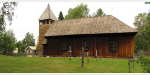 Die Seitenansicht der Gammelkyrka von Srna. Die Dcher von Kirchturm und Kirche sind mit unterschiedlich geformten Holzschindeln gedeckt.  Noch kunstvoller geformte Holzschindeln verkleiden die Wnde des Kirchturms. 