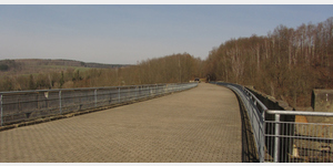 Blick auf den ehemaligen Bahndamm des Hetzdorfer Viadukts. Nach Stillsetzung des Bahnbetriebes im Jahre 1992 wurde der Damm auf gesamter Breite gepflastert und ist heute Teil des Fernwanderweges von der Ostsee zu den Saaletalsperren.