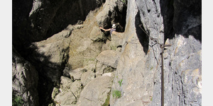 An der Soca-Quelle; die letzten Meter vor dem Felsspalt sind schon eine kleine Herausforderung an Mensch und Schuhwerk. Am Stahlseil geht es den schmalen Pfad entlang, ber die Steigeisen nach unten und ber die groen Steine hinber zur Felsspalte.