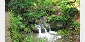 Der Schiessentmpel, ein dreistrmiger Wasserfall an der Schwarzen Ernz im luxemburgischen Mllerthal ist ber eine historische Steinbrcke zu besichtigen.