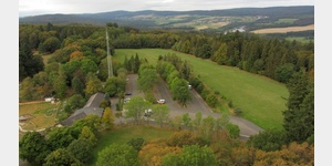Blick vom Aussichtturm der Wildenburg nach Westen, in Bildmitte der Parkplatz des Wildfreigeheges, rechts dahinter die Steinbachtalsperre bei Sensweiler.