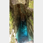 An der Soca-Quelle; nur wenige Schritte ber groe Steine sind es noch von den Steigeisen an der Felswand und man steht vor dem tiefen Felsspalt, aus dem das blau schimmernde Wasser strmt.