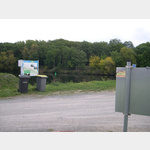 Das Bild zeigt die Rckseite der Infotafel vom Stellplatz mit dem aufgeklebten MEINWOMO-Schild, gegenber die Infos ber die Umgebung und der Main