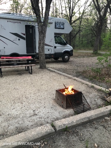 Typical campground with a fire pit and picnic bench